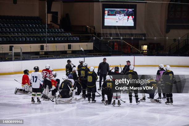 hockey team, sport training and strategy talk, formation and gameplan on ice rink with coach, teamwork and collation together. ice hockey, men and coaching after workout and sports exercise on ice - hockey black white stock pictures, royalty-free photos & images