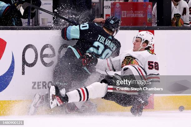 Eeli Tolvanen of the Seattle Kraken and MacKenzie Entwistle of the Chicago Blackhawks collide during the second period at Climate Pledge Arena on...