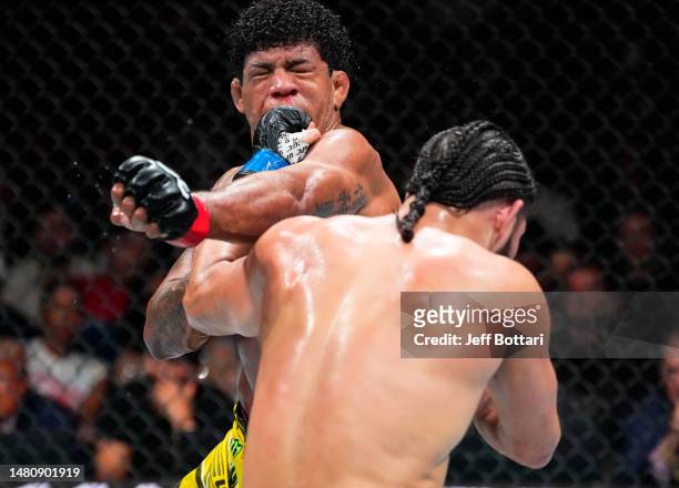 Jorge Masvidal punches Gilbert Burns of Brazil in a welterweight fight during the UFC 287 event at Kaseya Center on April 08, 2023 in Miami, Florida.