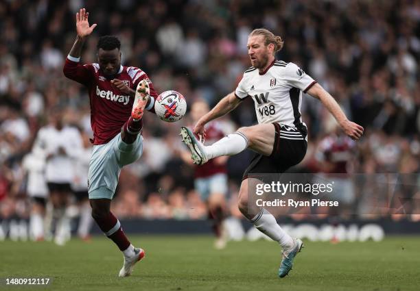 Maxwel Cornet of West Ham United competes for the ball against Tim Ream of Fulham during the Premier League match between Fulham FC and West Ham...