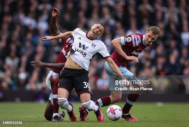 Carlos Vinicius of Fulham is challenged by Kurt Zouma and Tomas Soucek of West Ham United during the Premier League match between Fulham FC and West...