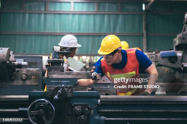 a group of factory workers are using factory lathes to work in the factory, and there is a strict patrol by a female engineer. - milling cutter stock pictures, royalty-free photos & images