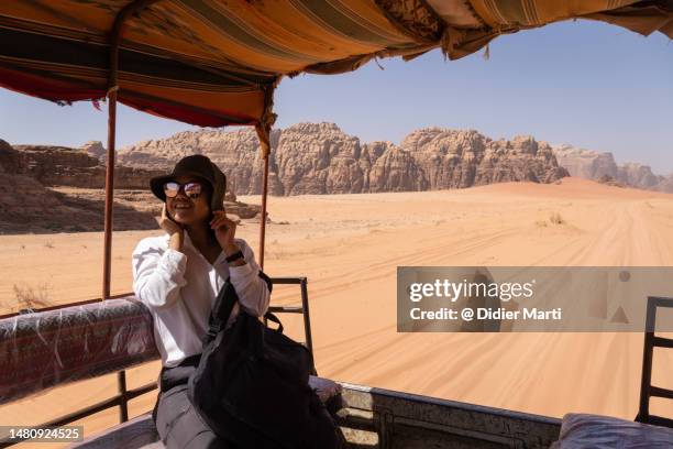 tourist riding a jeep in wadi rum desert in jordan - hot middle eastern women stock-fotos und bilder