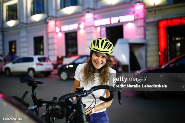 portrait of woman with bicycle and car bicycle rack. woman looking at camera - training wheels stock pictures, royalty-free photos & images