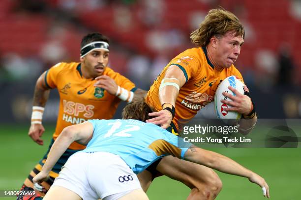 Darby Lancaster of Australia runs with the ball against Koba Brazionis of Uruguay in their 5th place semifinal match during the HSBC Singapore Rugby...