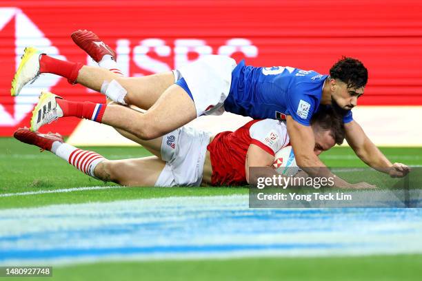 Ross McCann of Great Britain scores a try against Rayan Rebbadj of France in their 5th place semifinal match during the HSBC Singapore Rugby Sevens...