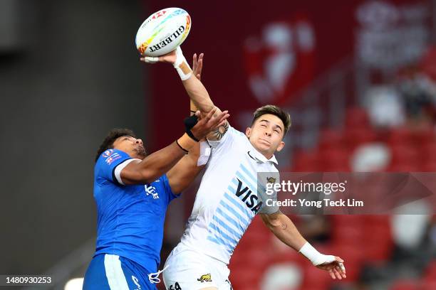 Taunuu Niulevaea of Samoa and Marcos Moneta of Argentina compete for the ball in their cup semifinal match during the HSBC Singapore Rugby Sevens at...