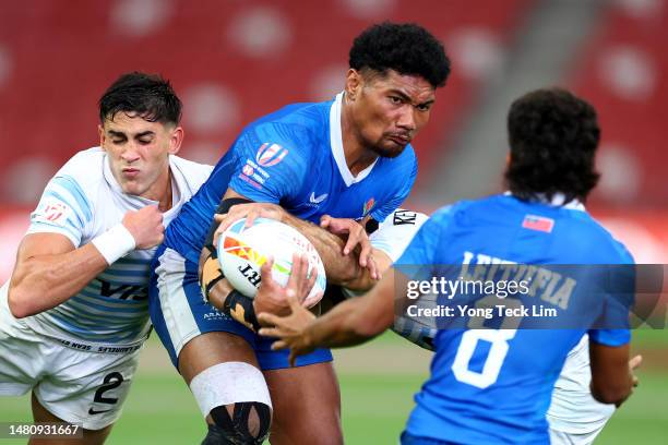 Faafoi Falaniko of Samoa runs with the ball against a tackle by Santiago Vera Feld and Gaston Revol of Argentina in their cup semifinal match during...