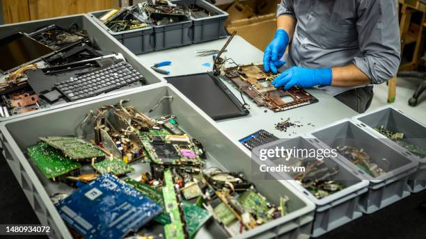 man in disposable gloves disassembling laptop - e waste stock pictures, royalty-free photos & images