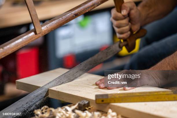 craftsman cutting wood with hand saw - hand sawing wood stock pictures, royalty-free photos & images