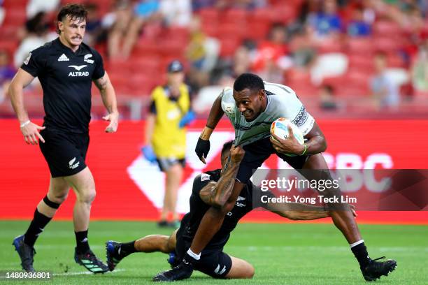 Joseva Talacolo of Fiji runs with the ball for a try against Regan Ware of New Zealand in their cup semifinal match during the HSBC Singapore Rugby...