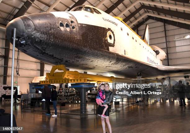 Gigi Edgley and daughter Skye pose underneath the Space Shuttle Endeavor at Yuri's Night Los Angeles held at California Science Center on April 08,...