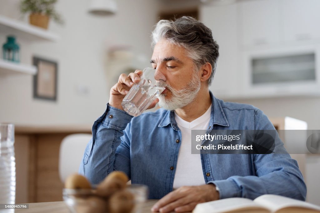 Hombre bebiendo agua en casa