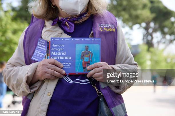 Podemos supporter with a sign that reads 'Hay que arreglar Madrid corriendo' during a popular race, in El Retiro Park, on April 9 in Madrid, Spain....