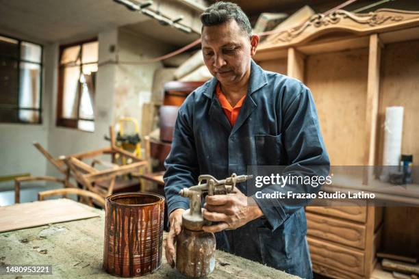 mature man preparing spray gun at carpentry - spray gun stock pictures, royalty-free photos & images