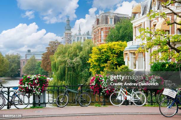 brücke über einen amsterdamer kanal an einem sonnigen tag mit klarem himmel. - amsterdam bike stock-fotos und bilder