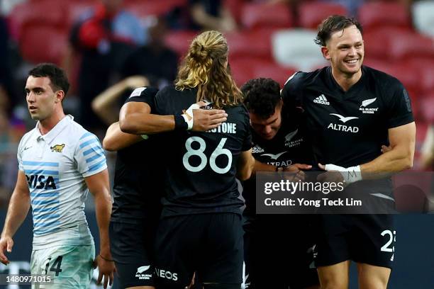 The New Zealand team celebrates after winning the cup final match against Argentina during the HSBC Singapore Rugby Sevens at the National Stadium on...