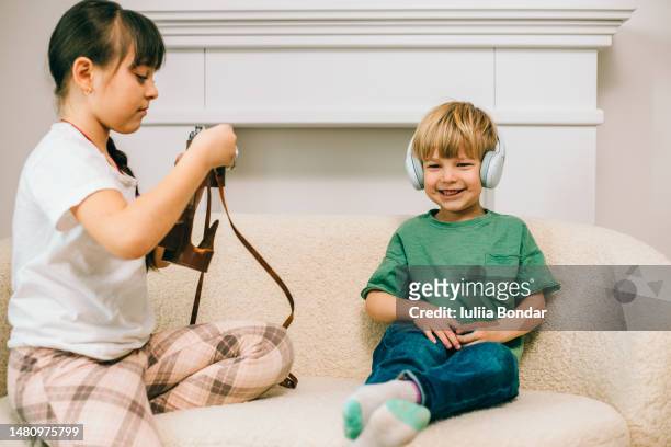 little brother and teenage sister playing using technology - little brother stock pictures, royalty-free photos & images