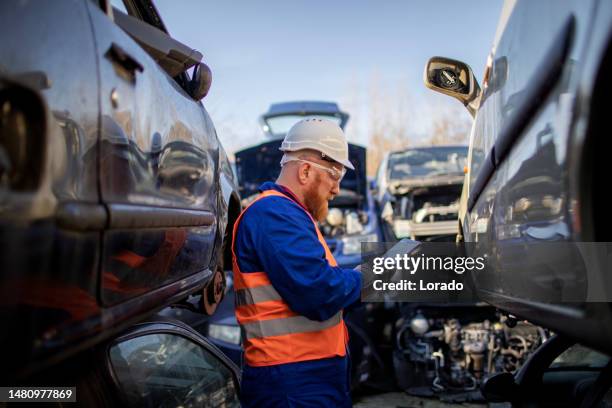 male worker in an automotive junkyard - junkyard stock pictures, royalty-free photos & images