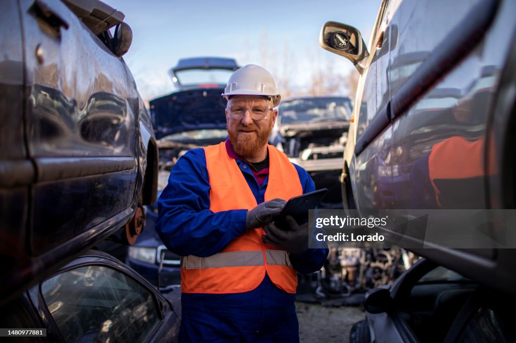 Male worker in an automotive junkyard