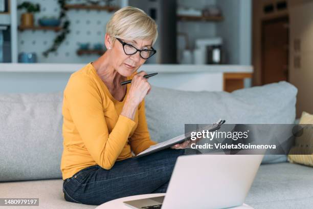ältere frau, die das budget verwaltet und rechnungen und steuern bezahlt. - lebensversicherung stock-fotos und bilder
