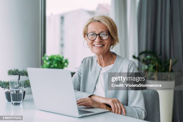 erfolgreiche geschäftsfrau im modernen büro, die am laptop arbeitet. - 50 54 jahre stock-fotos und bilder