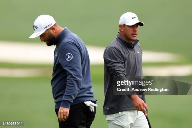 Jon Rahm of Spain and Brooks Koepka of the United States look on from the tenth green during the continuation of the weather delayed third round of...