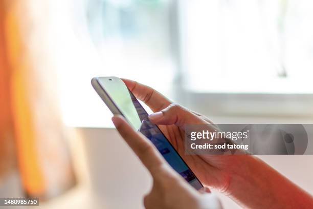 finger pointing on mobile phone screen close-up, man sending text message, blue screen hipster touching on smartphone night light city young woman using mobile phone in hand close-up, online internet - young woman close at home stock pictures, royalty-free photos & images