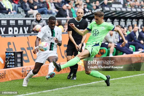 Marcus Thuram of Borussia Moenchengladbach battles for possession with Micky van de Ven of VfL Wolfsburg during the Bundesliga match between Borussia...