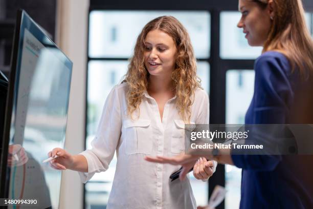 performance bench-marking can improve and make data-driven decisions about the business. the business team having a discussion on problem-solving business data at a led screen in a modern tech business office. - data analyst stock pictures, royalty-free photos & images