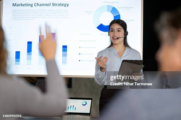 launching new products in the market creates an awareness of the product among consumers. young businesswoman sharing statistics and growth rate of market share to the attendees during a product launch live event. - q and a stock pictures, royalty-free photos & images