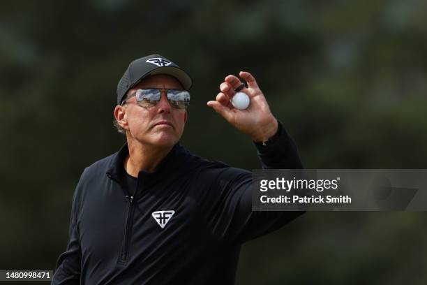 Phil Mickelson of the United States catches a ball on the 18th green during the continuation of the weather delayed third round of the 2023 Masters...