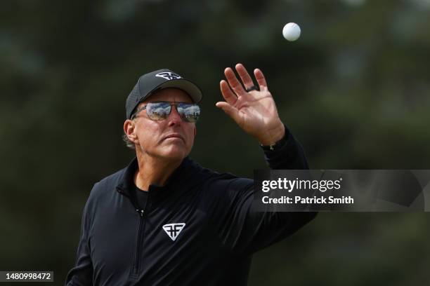 Phil Mickelson of the United States catches a ball on the 18th green during the continuation of the weather delayed third round of the 2023 Masters...