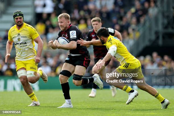 Jackson Wray of Saracens runs with the ball whilst under pressure from Jules Favre of Stade Rochelais during the Heineken Champions Cup match between...