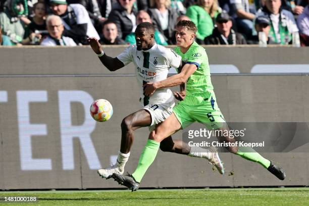 Marcus Thuram of Borussia Moenchengladbach is challenged by Micky van de Ven of VfL Wolfsburg during the Bundesliga match between Borussia...