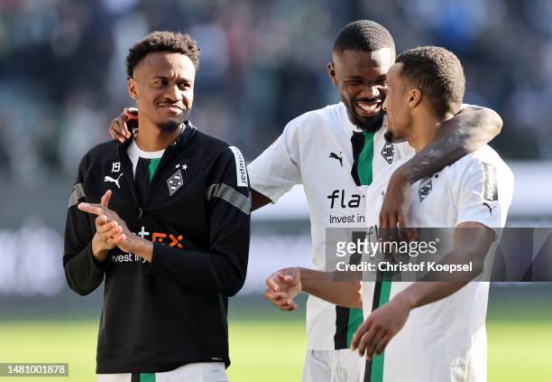 Nathan Ngoumou, Marcus Thuram and Alassane Plea of Borussia Moenchengladbach interact as they celebrate victory following the Bundesliga match...