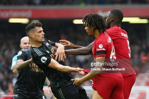 Granit Xhaka of Arsenal is confronted by Trent Alexander-Arnold and Ibrahima Konate of Liverpool during the Premier League match between Liverpool FC...