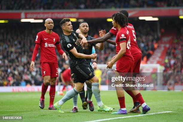 Granit Xhaka of Arsenal is confronted by Trent Alexander-Arnold and Ibrahima Konate of Liverpool during the Premier League match between Liverpool FC...