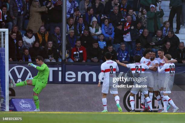 Josha Vagnoman of VfB Stuttgart celebrates with teammates after scoring the team's third goal, as Manuel Riemann of VfL Bochum 1848 reacts during the...