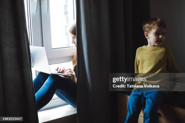 hide and seek game, mother trying to work and video calling, hiding on windowsill covering with curtains. little boy trying to find mom - hide and seek stock pictures, royalty-free photos & images