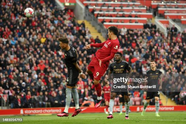 Roberto Firmino of Liverpool scores the team's second goal whilst under pressure from Ben White of Arsenal during the Premier League match between...