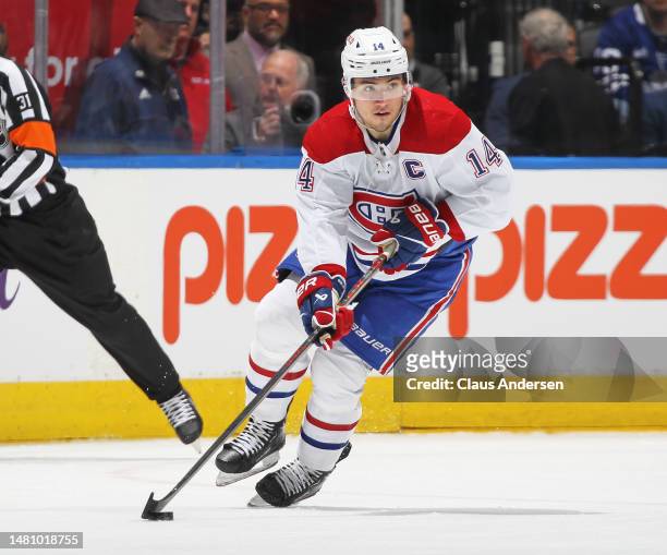 Nick Suzuki of the Montreal Canadiens skates with the puck against the Toronto Maple Leafs during an NHL game at Scotiabank Arena on April 8, 2023 in...
