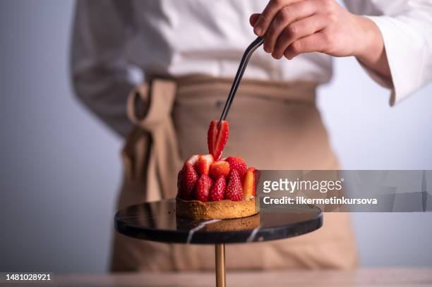 chef haciendo un pastel con fresas - decorating a cake fotografías e imágenes de stock