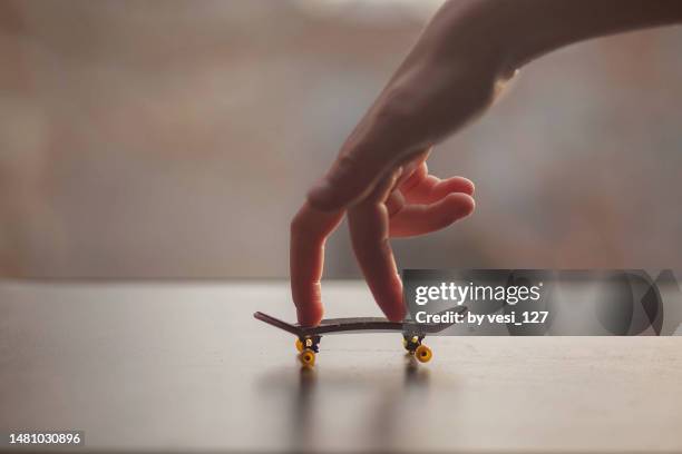 riding a mini skateboard or fingerboard - extreem weer stock pictures, royalty-free photos & images