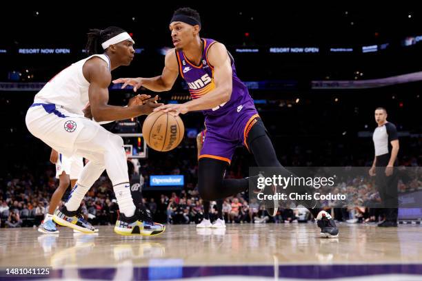 Darius Bazley of the Phoenix Suns drives against Terance Mann of the Los Angeles Clippers during the first half of the game at Footprint Center on...