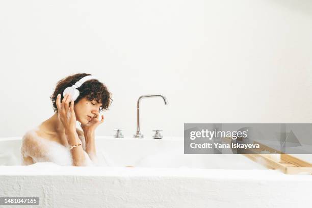 a beautiful young woman listening to music in wireless white headphones, having "me time" - me time stock pictures, royalty-free photos & images