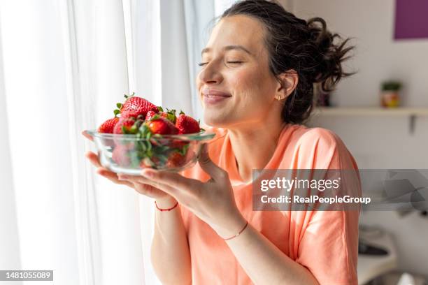 woman indulging in delicious strawberries for dessert - strawberry stock pictures, royalty-free photos & images