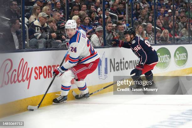 Kaapo Kakko of the New York Rangers controls the puck along the board while Jack Roslovic of the Columbus Blue Jackets defends during the first...