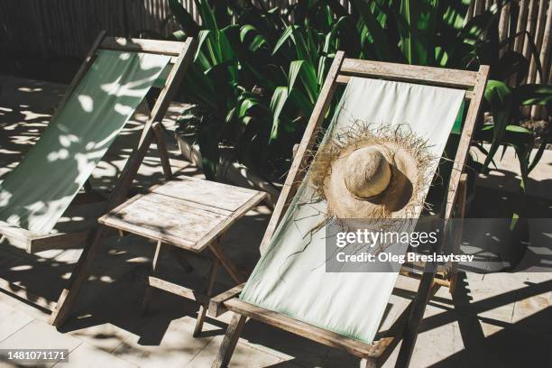 straw summer hat on wooden sunbeds in sunshine. sustainable beach equipment - tanning bed stock pictures, royalty-free photos & images