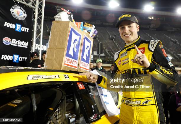 Christopher Bell, driver of the DeWalt Power Stack Toyota, poses next to his winner sticker in victory lane after winning the NASCAR Cup Series Food...